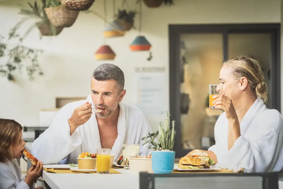 Famiglia in accappatoio che fa colazione al Parco Termale. Relax e benessere.