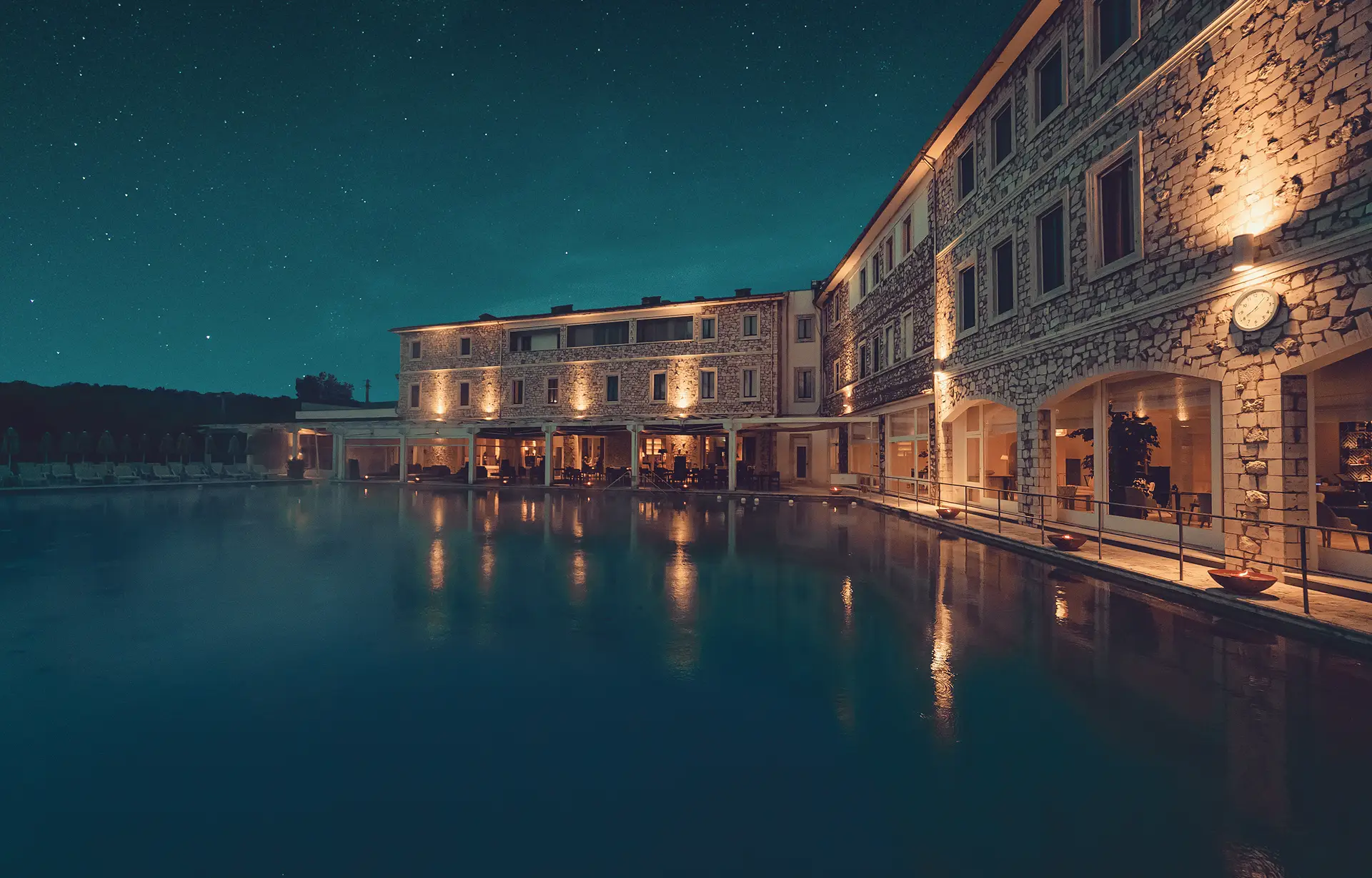 Hotel di lusso con piscina illuminata di notte sotto un cielo stellato. Club.