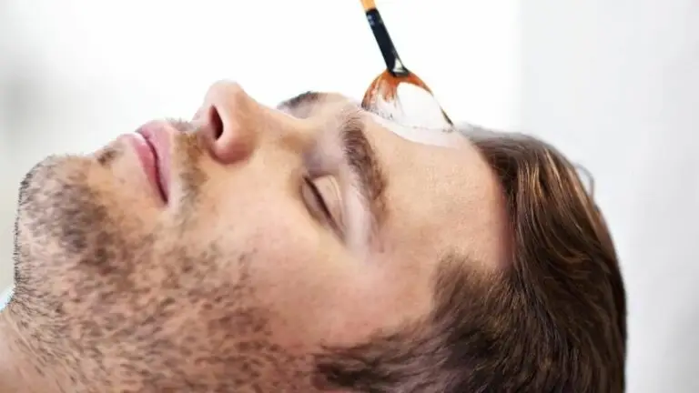 Uomo che riceve trattamento viso con pennello. Saturn for men.