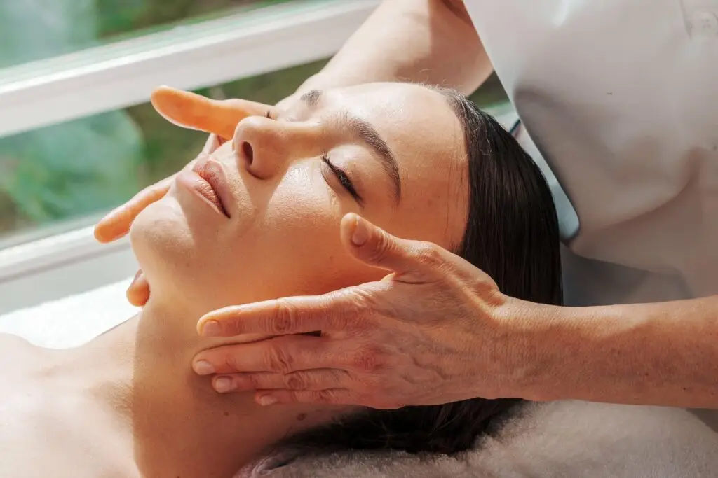 Donna che riceve un massaggio facciale rilassante in un centro benessere.