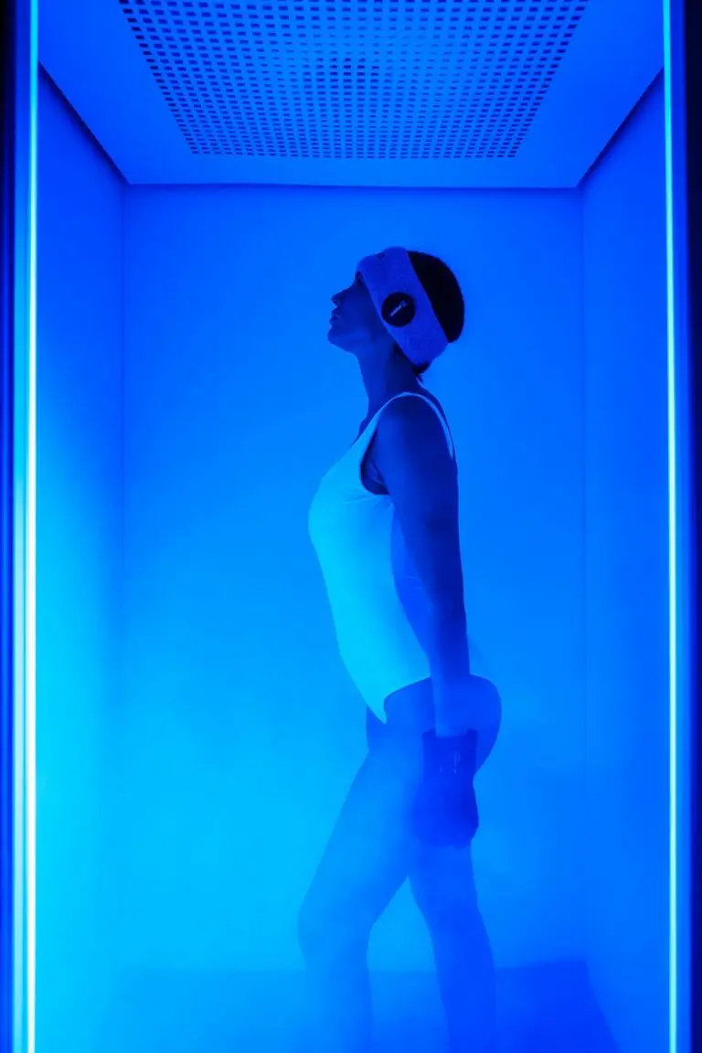 Donna in cabina per trattamento benessere con luce blu. Massaggi e trattamenti.