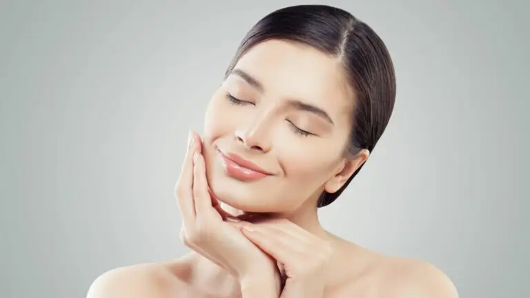 Donna con pelle perfetta e occhi chiusi che tocca il viso. Cura della pelle.