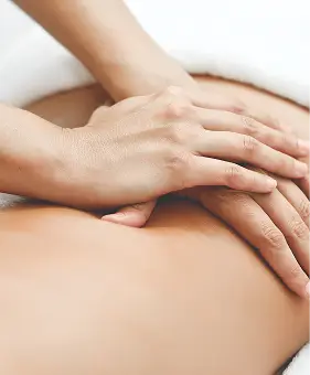 Massaggio terapeutico alla schiena con mani di terapista. Benessere al centro medico.