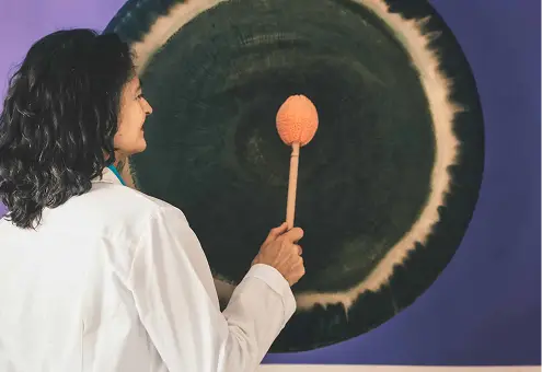 Naturopata suona gong. Terapia del suono con gong. Benessere.