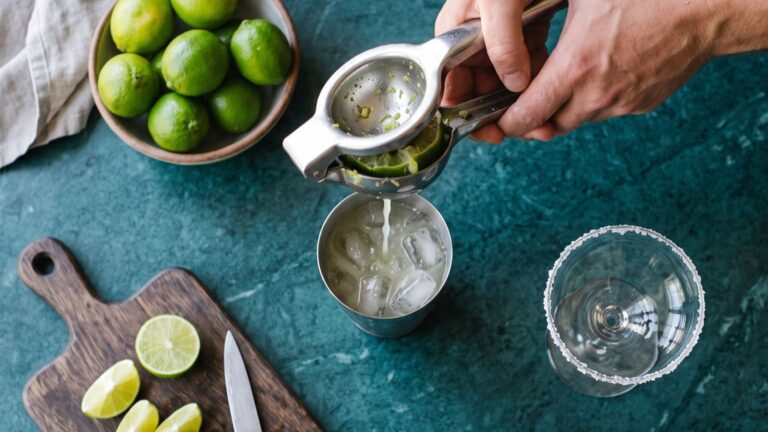 Spremitura di lime per cocktail con ghiaccio e bicchiere bordato di sale