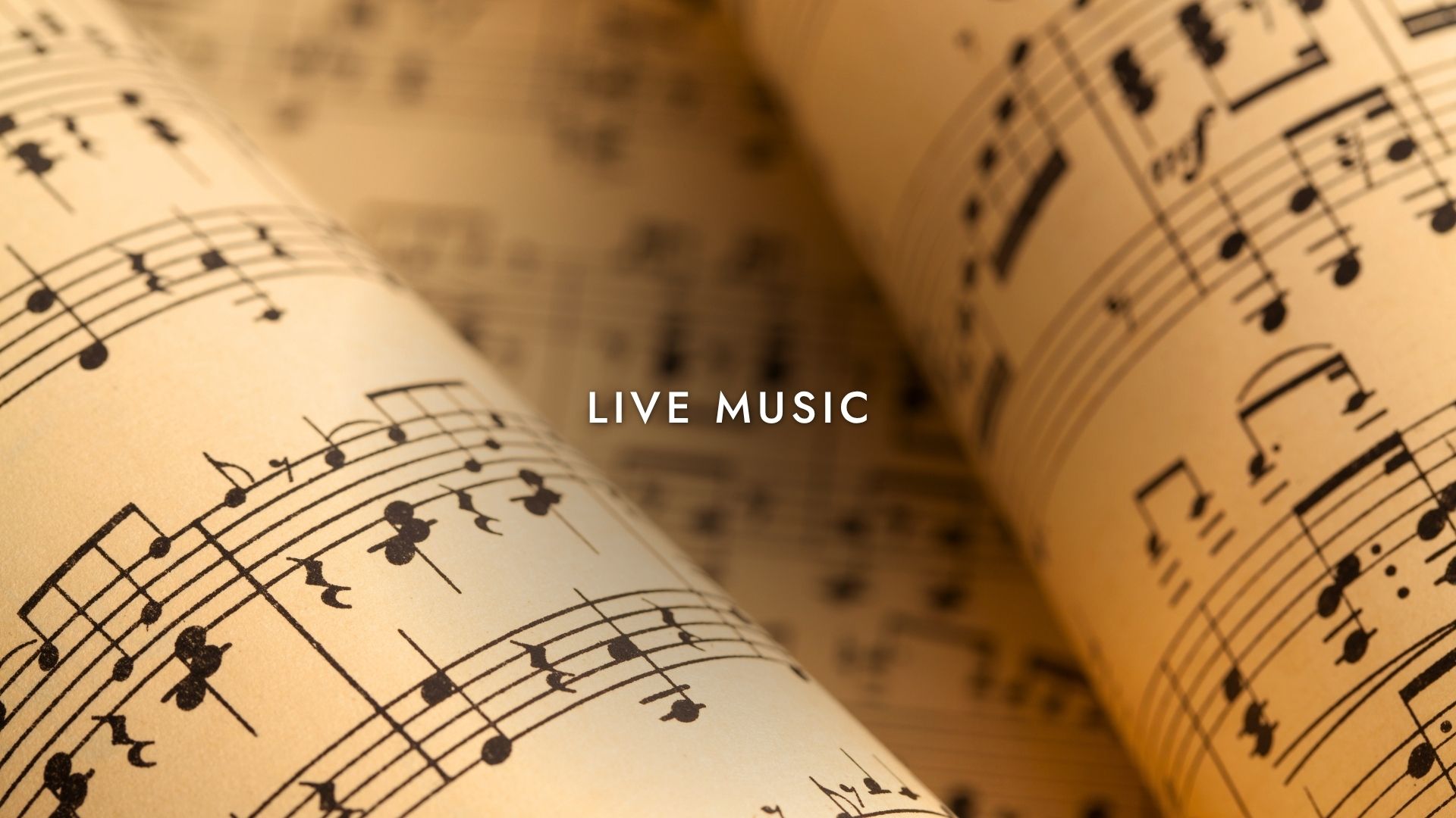 Partitura musicale arrotolata con testo "Live Music